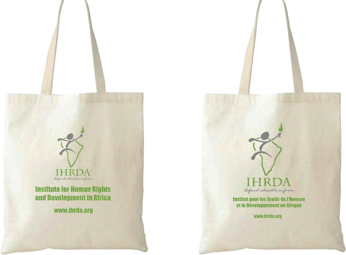 Two natural canvas tote bags printed with the IHRDA logo and full organisation name in English and French.